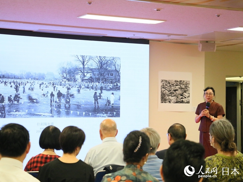 拍攝者介紹展出作品。人民網(wǎng) 許可攝
