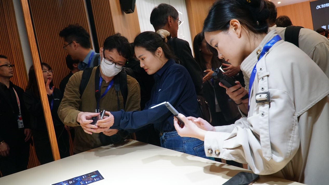 發(fā)布會(huì)上，與會(huì)嘉賓試用訊飛雙屏翻譯機(jī)2.0。人民網(wǎng) 蔣曉辰攝
