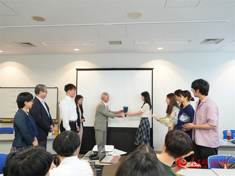 訪華團代表向東京都日中友好協(xié)會成員獻花致謝。人民網(wǎng) 許可攝